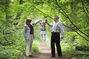 Young grandparents playing with their baby granddaughter in an a